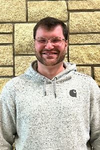 Headshot of a male with glasses and dark hair